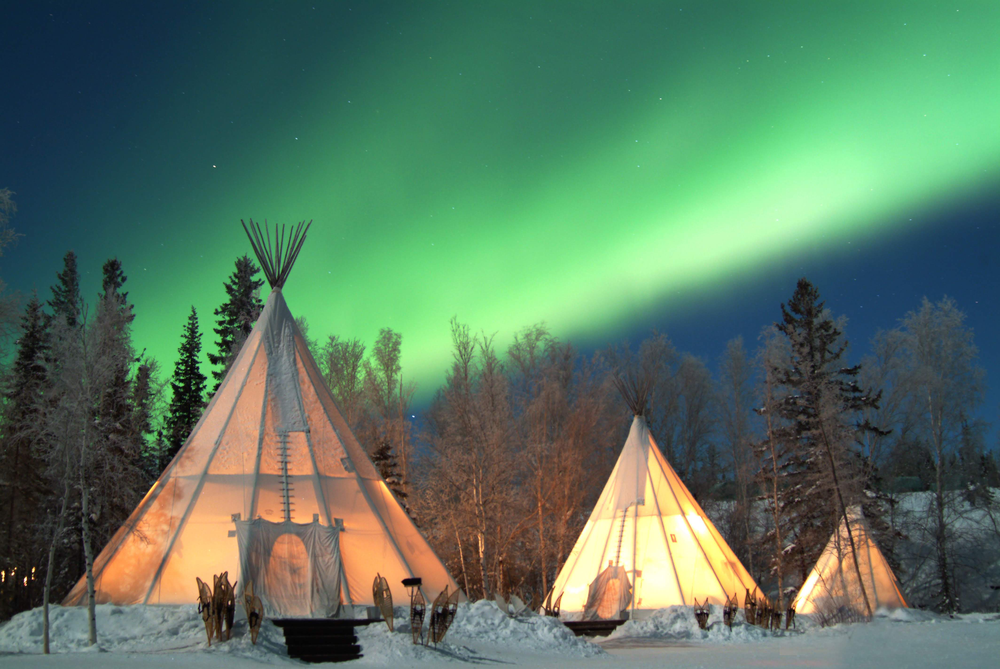 Das Nordlicht in Kanada von einem Zelt im Schnee aus zu sehen.
